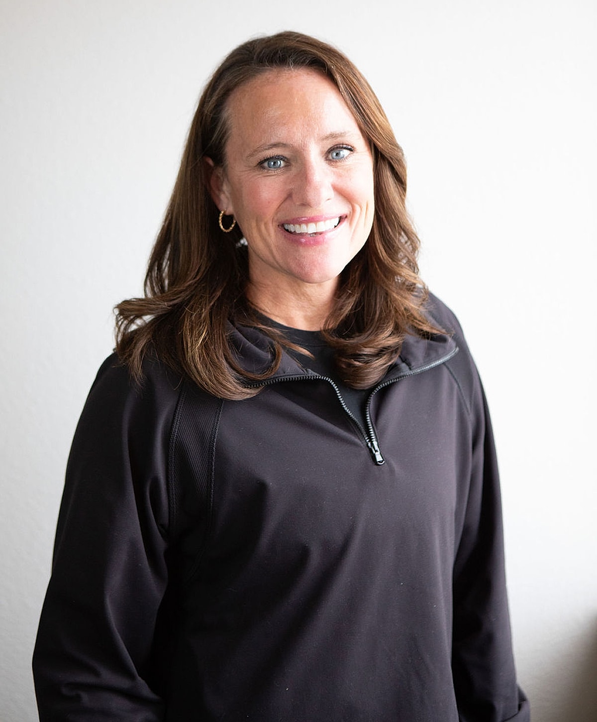 Smiling woman in black athletic wear.