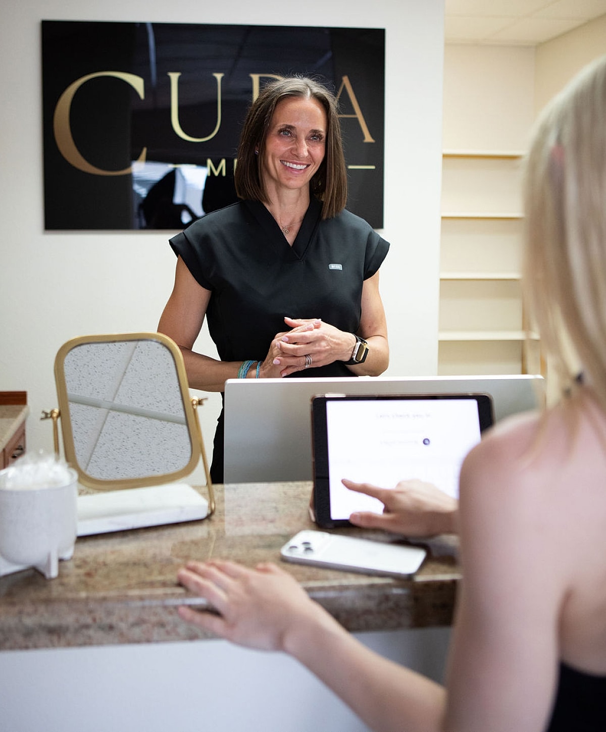 Receptionist welcoming a client at a medical office.