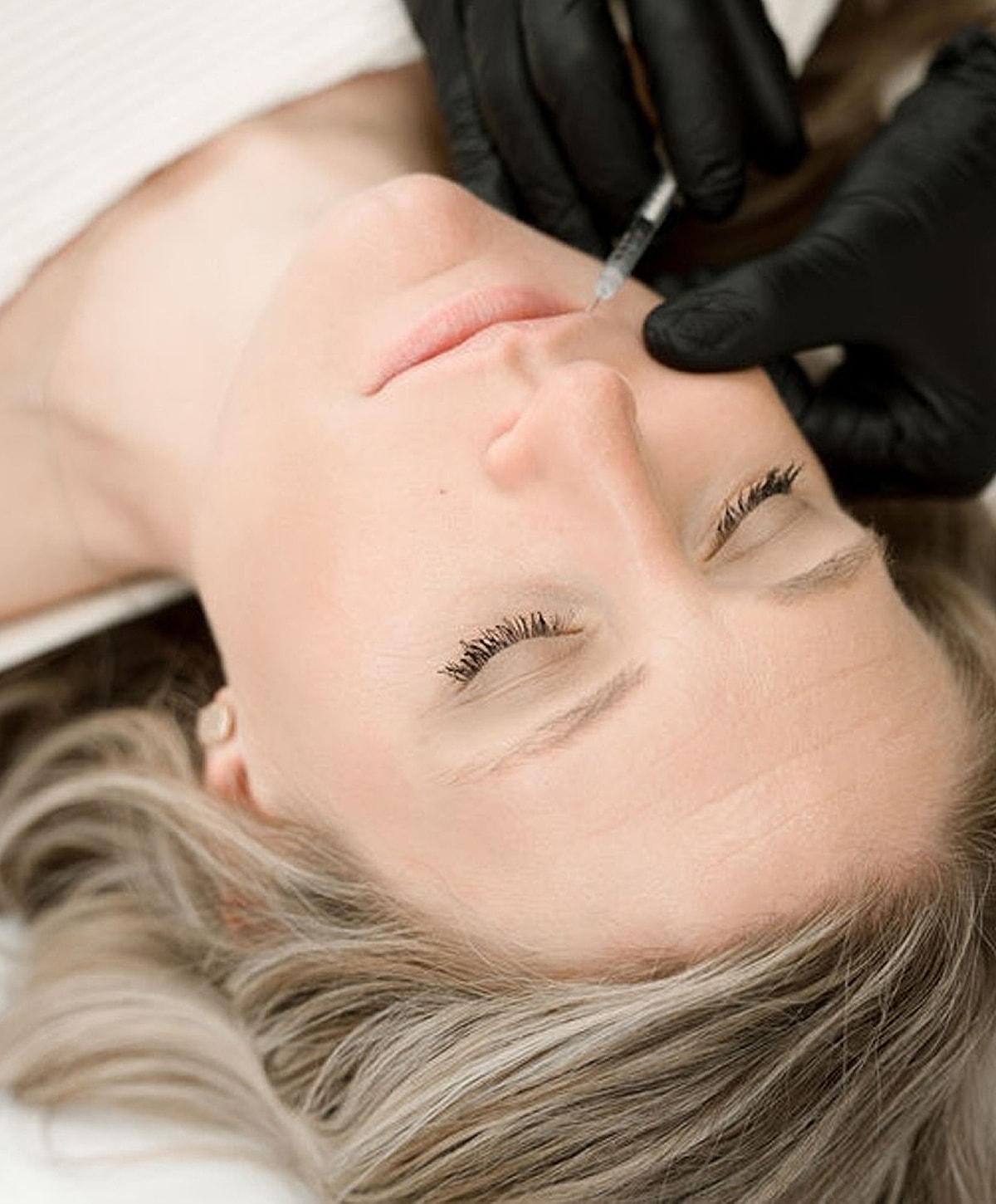Injecting treatment on a woman's lips.