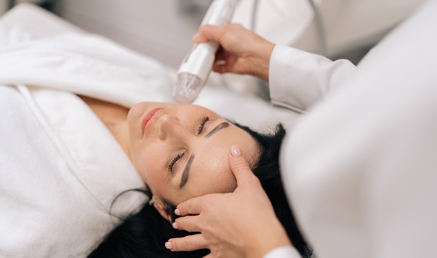 Woman receiving a facial treatment in clinic.