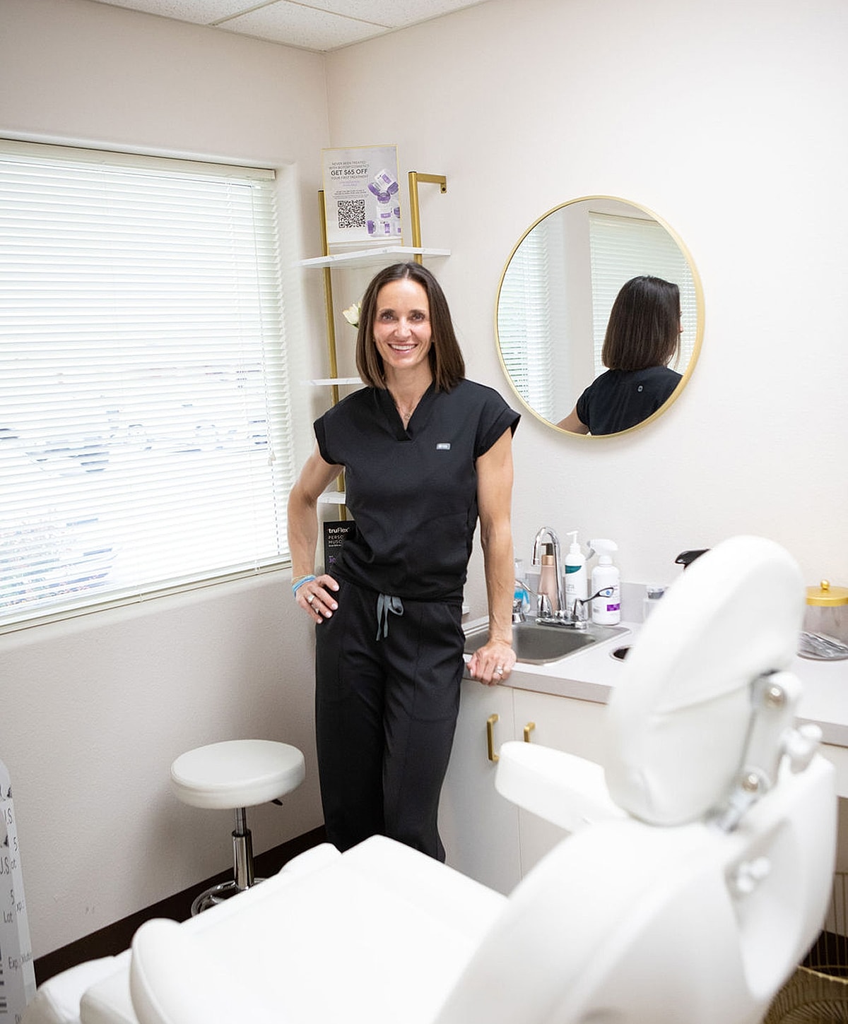 Professional in medical office with treatment chair.