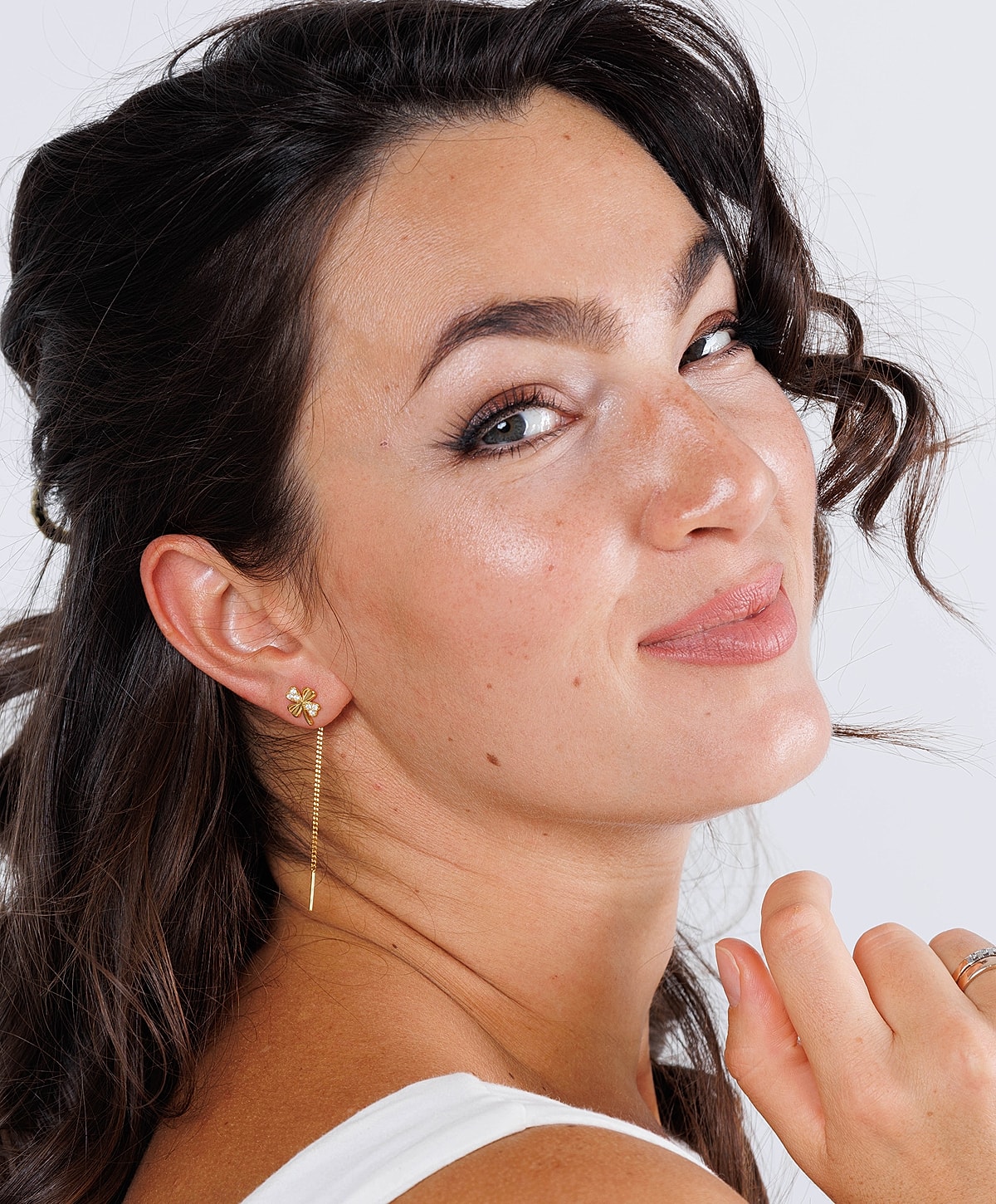 Smiling woman with elegant earrings and natural makeup.