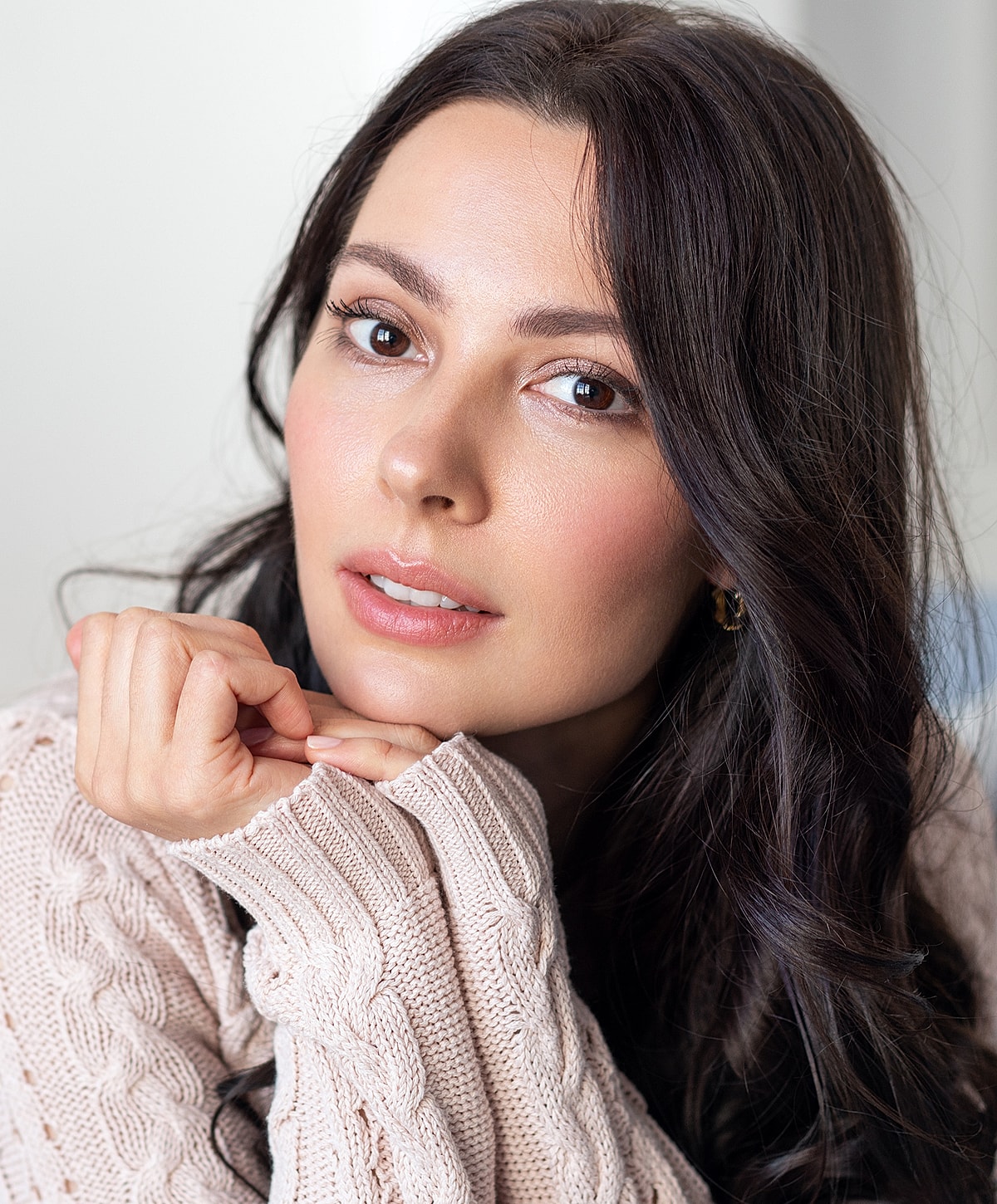 Woman with long dark hair, wearing a sweater.