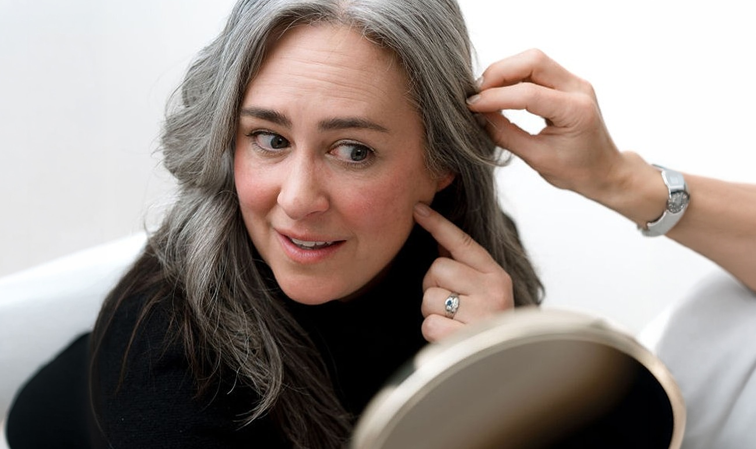 Woman examining her reflection in a mirror.